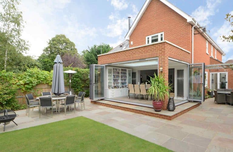 Orangery extension creates with aluminium bifolding doors opening from kitchen to garden.