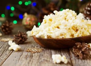 popcorn in a wooden bowl on the background of Christmas and New Year's decorations, selective focus