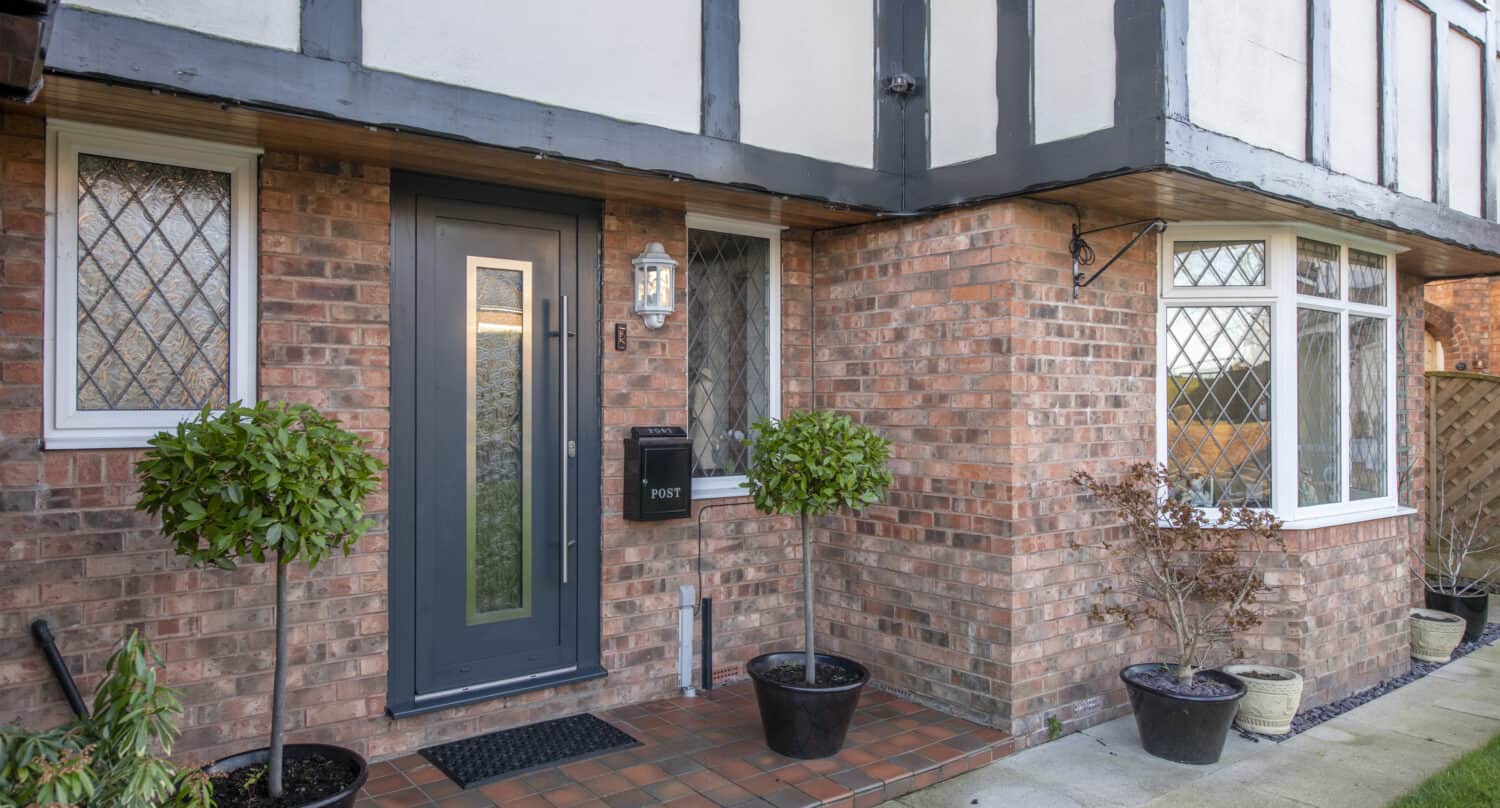 Modern front door in anthracite paired with white windows