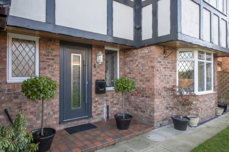 Modern front door in anthracite paired with white windows