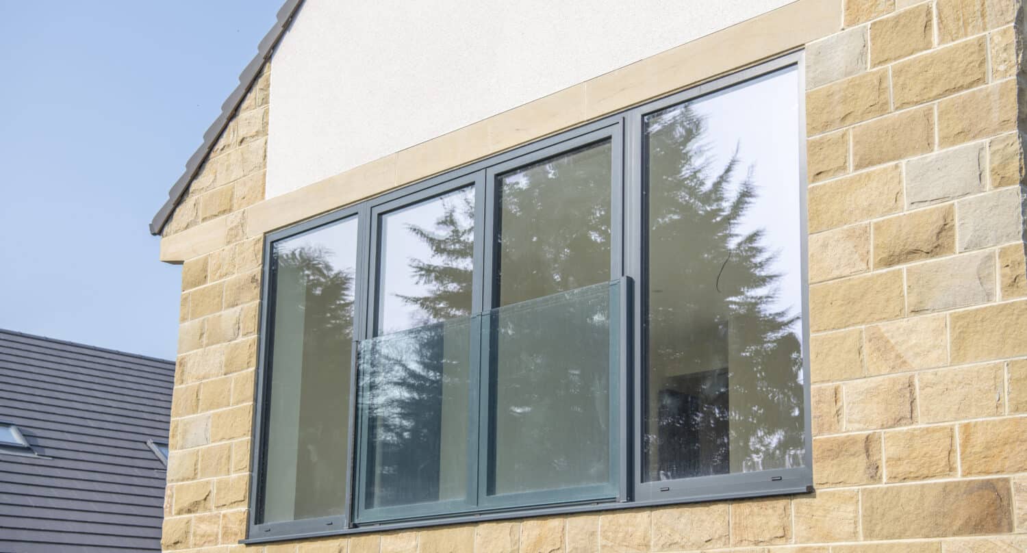 Large aluminium windows with glass balustrade balcony