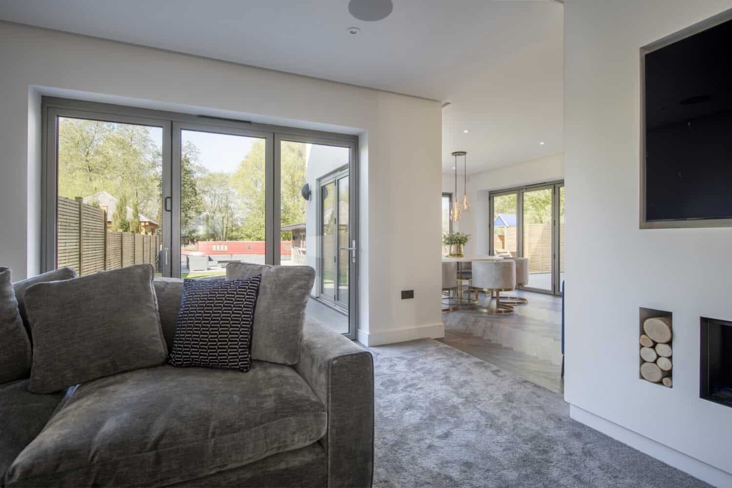 Bespoke aluminum grey doors illuminating a modern living room