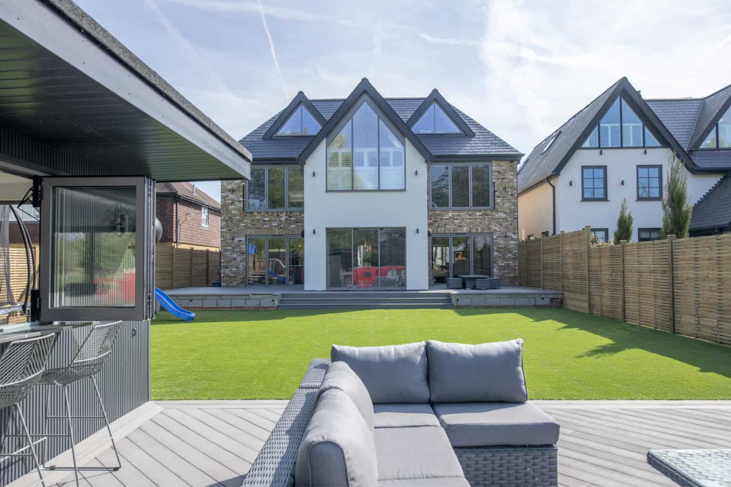 Outdoor garden social space looking at bespoke aluminum windows and doors