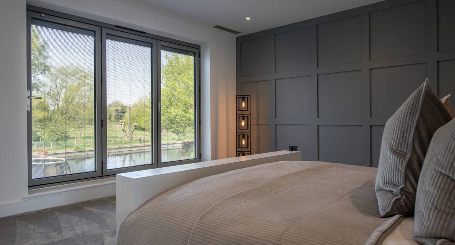 Modern double bedroom with contemporary grey bi folding windows