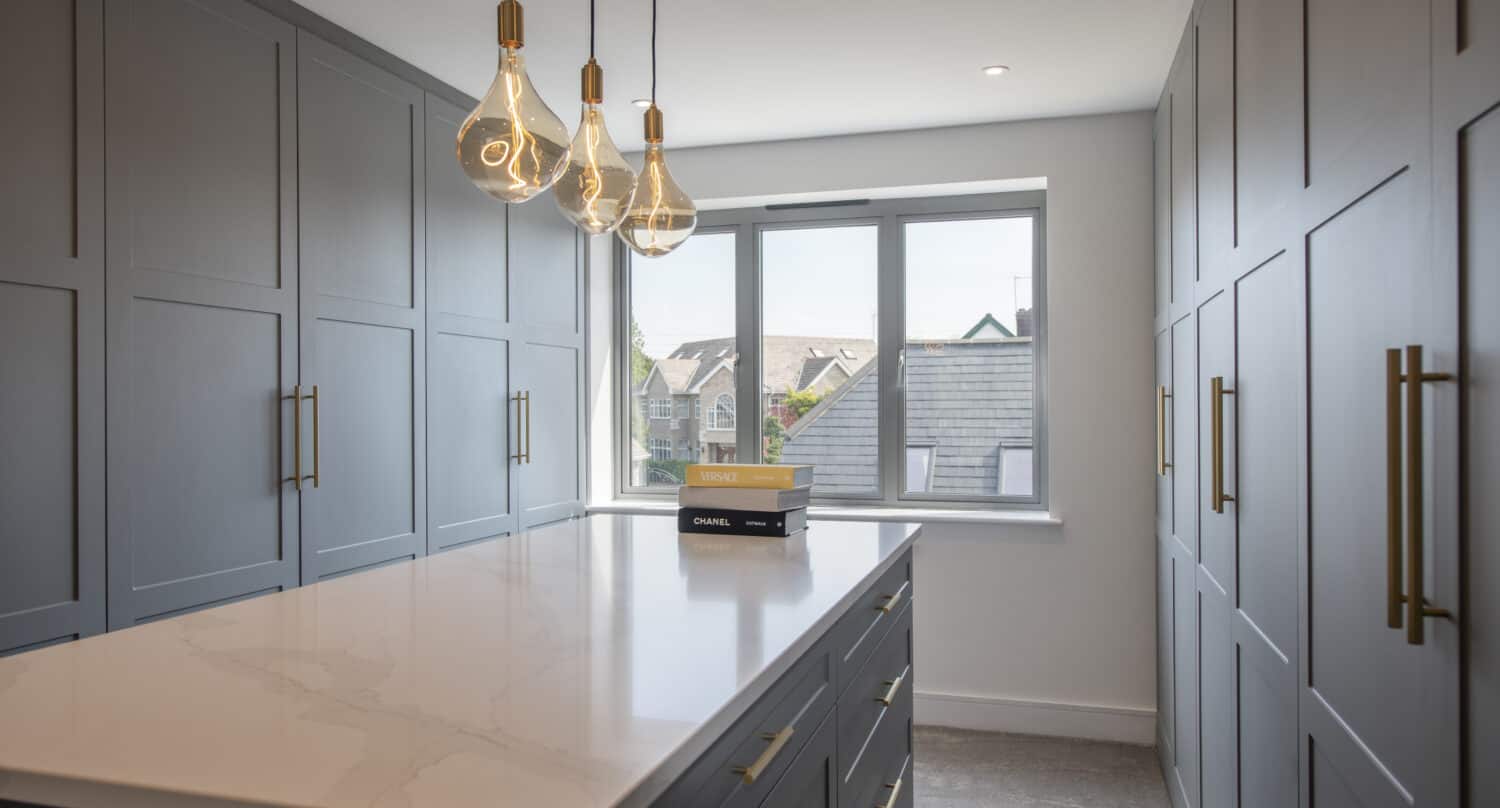 Luxury walking wardrobe room featuring fitted wardrobes and grey windows