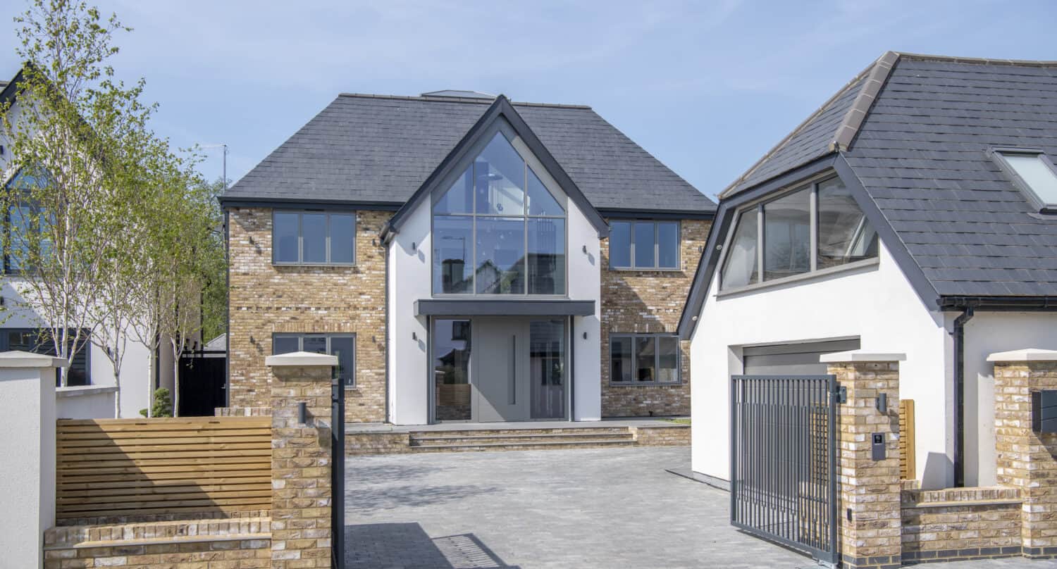 Detached modern home with bespoke aluminum entrance doors and shaped windows