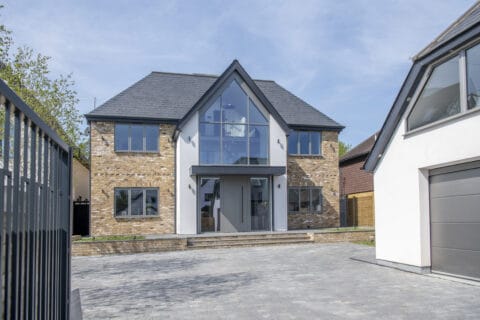 Luxury detached house featuring a modern front door with side panels