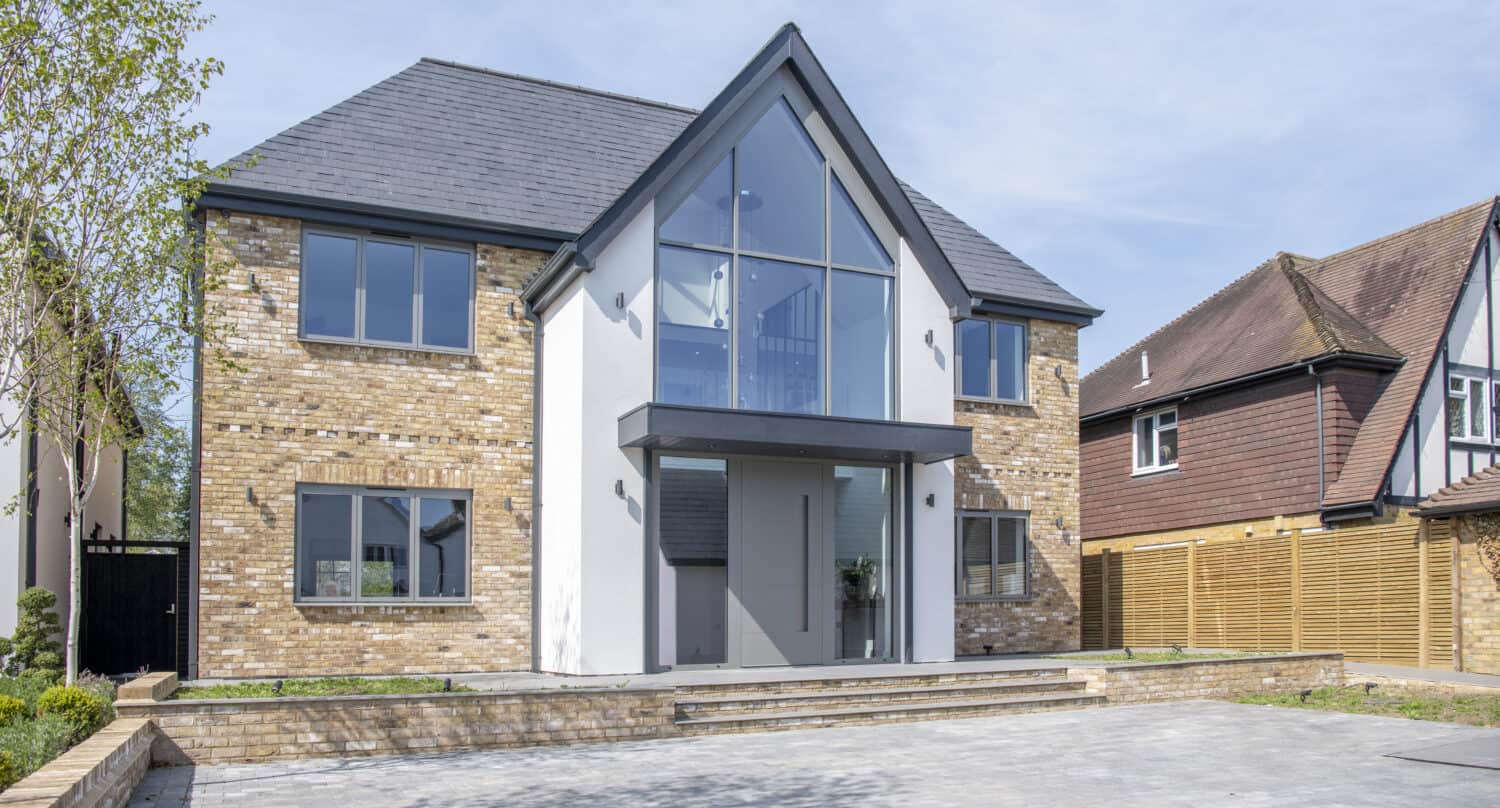 Luxury detached house featuring grey windows and modern from door with side panels