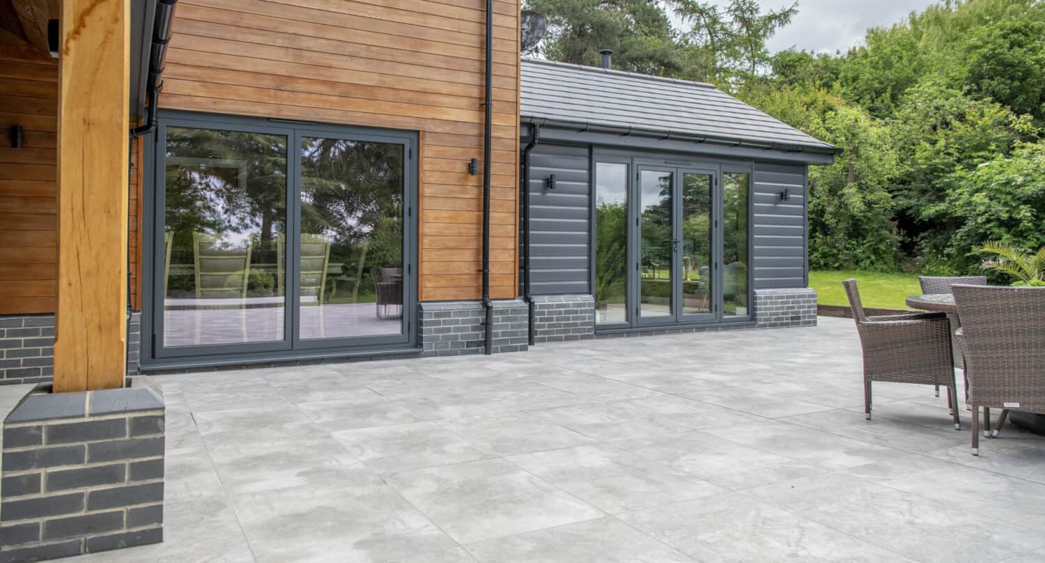 Side view of a modern home extension featuring black patio doors