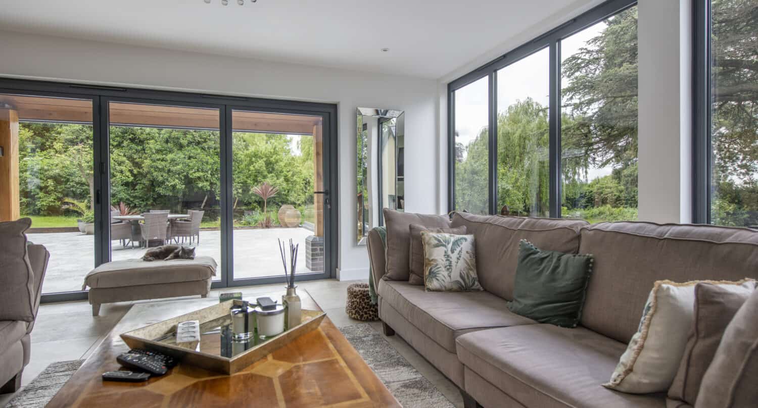 Modern living room space featuring grey aluminium bifold doors connecting the outdoor patio