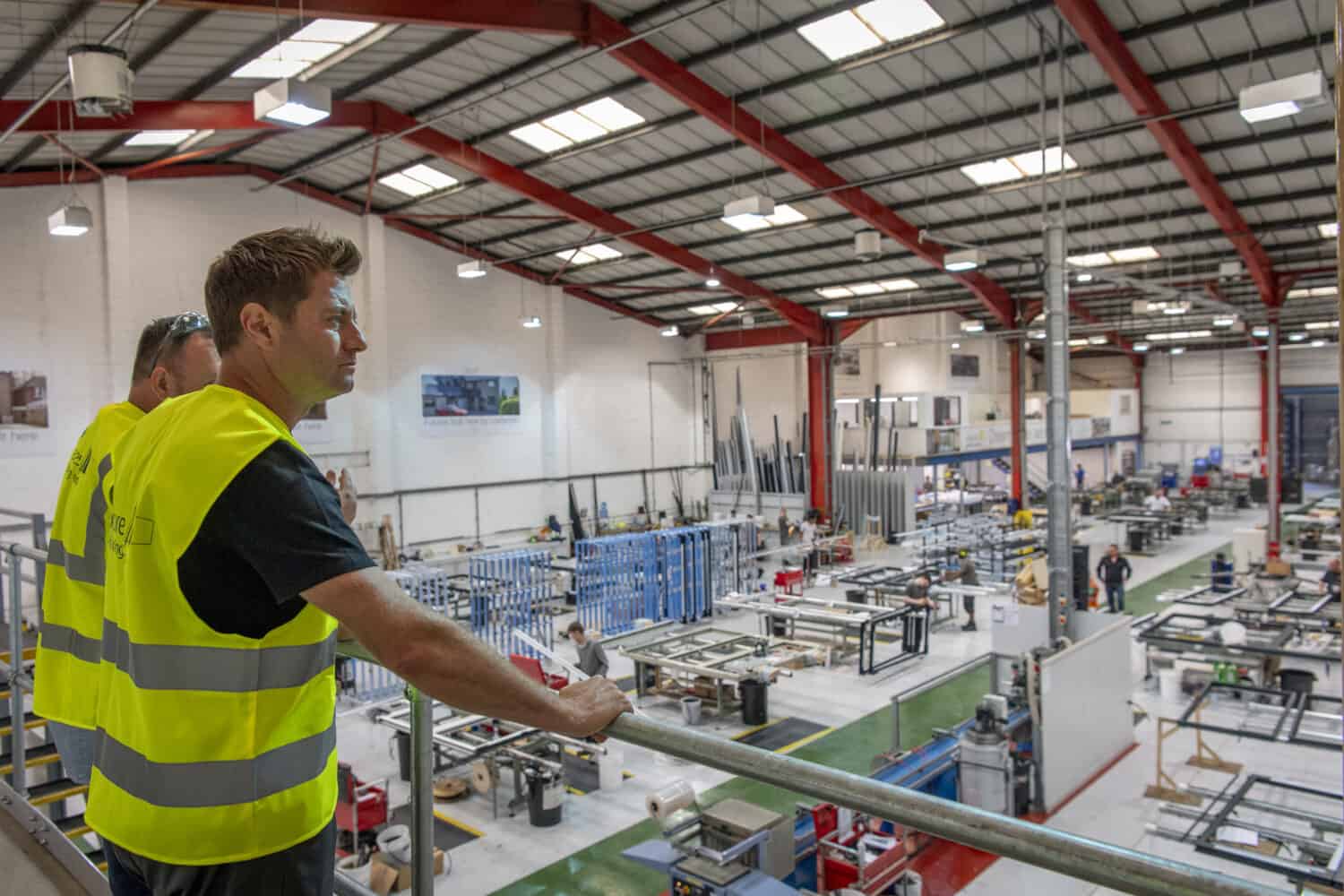 Two men supervising the work in a bifolding doors and windows manufacturing warehouse