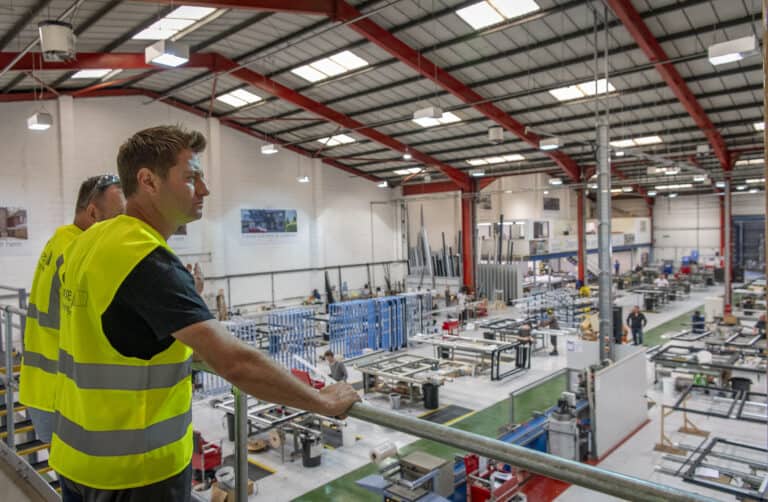 Two men supervising the work in a bifolding doors and windows manufacturing warehouse