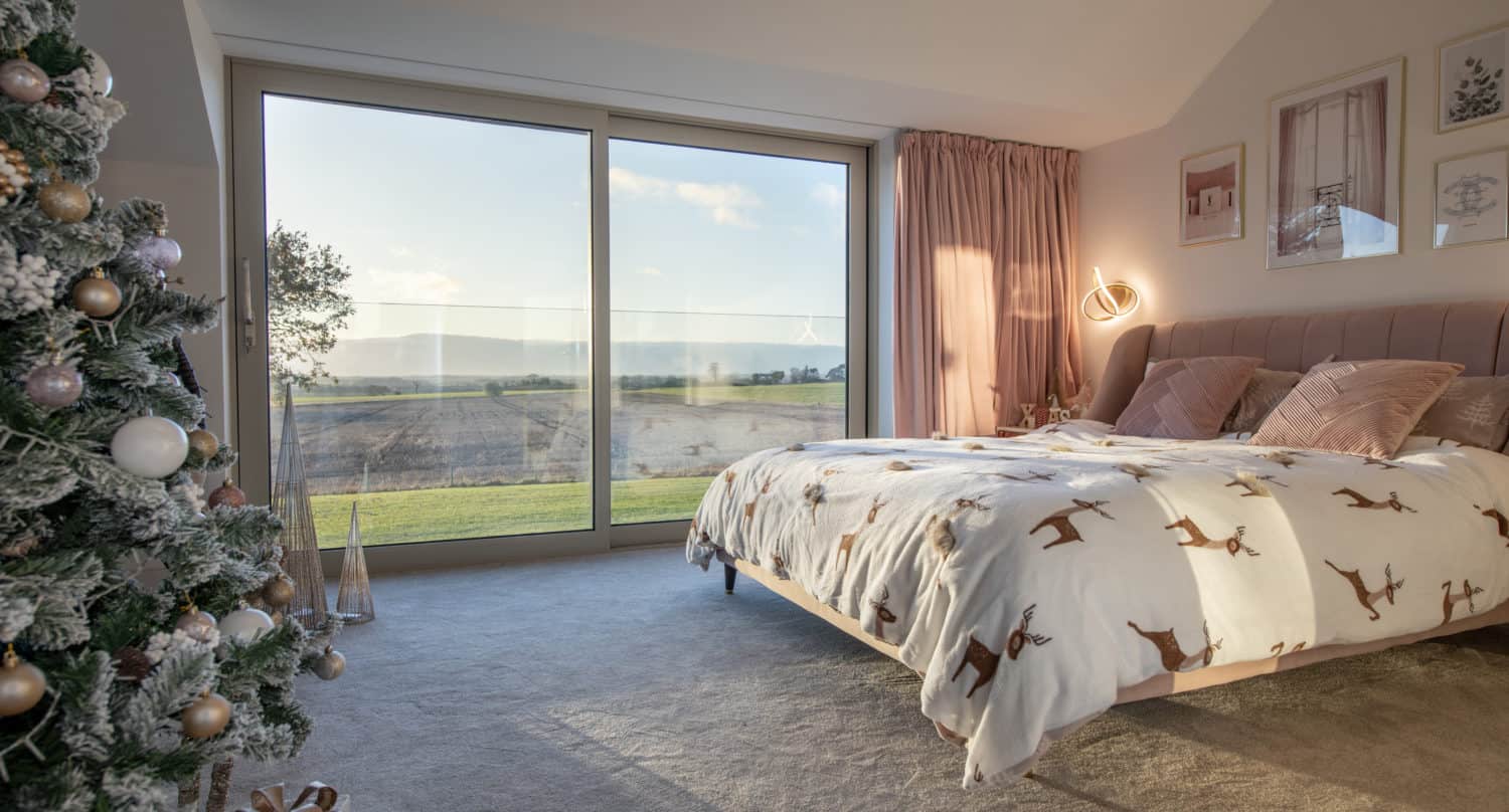 Bedroom with a christmas tree and aluminium windows