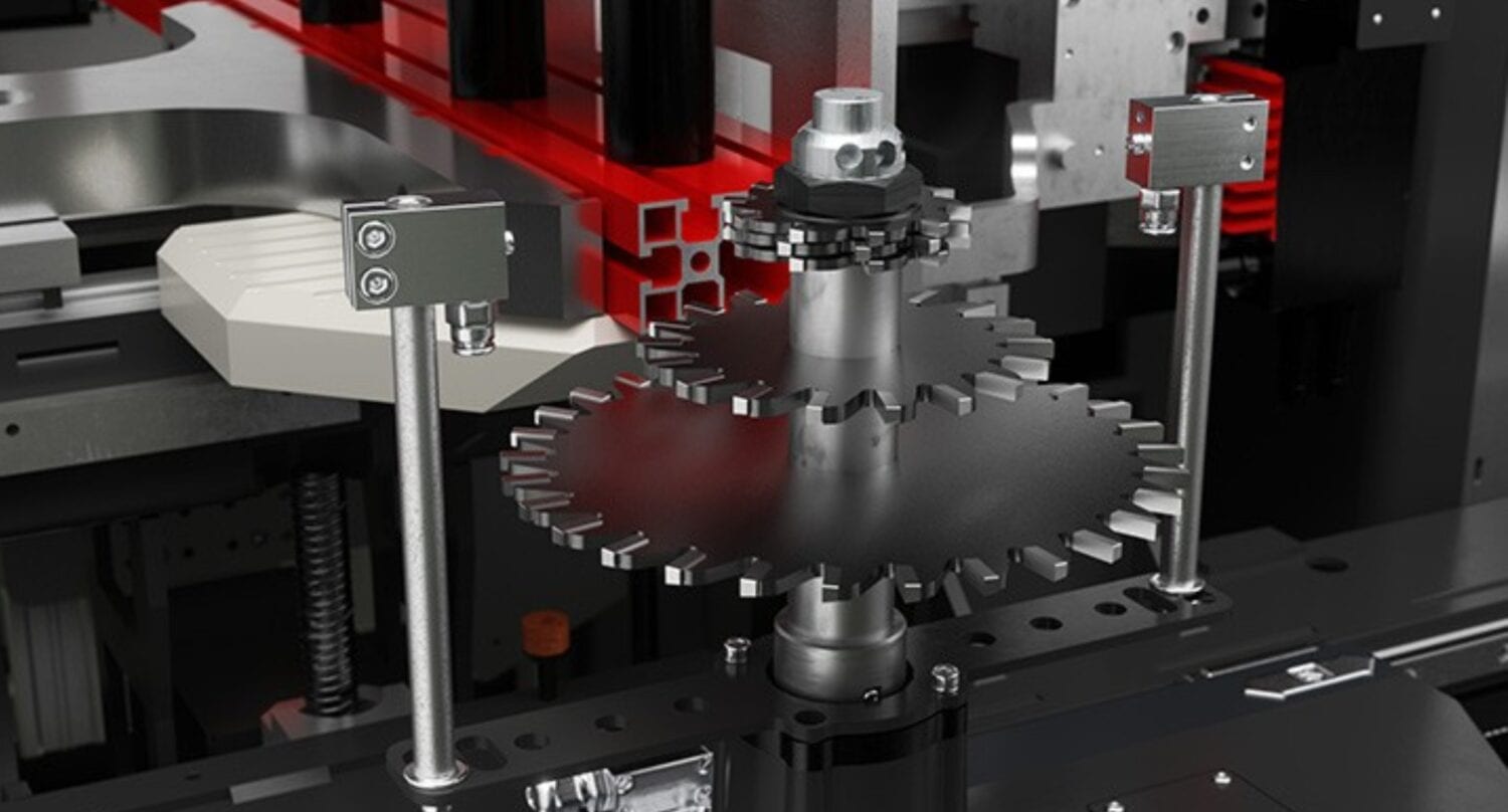 Close-up of interlocking metal gears and machinery parts in a modern industrial machine, highlighting mechanisms commonly found in sliding doors, with a red horizontal bar and metallic supports visible in the background.