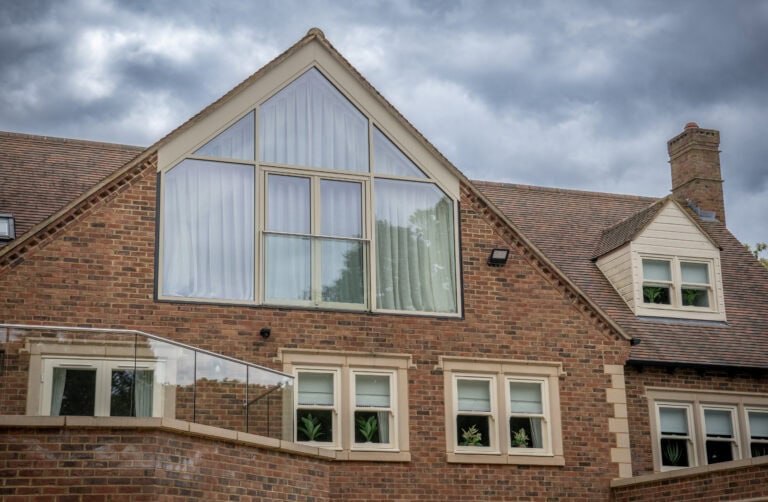 Contemporary house with large glass windows and a glass extension, showcasing modern design and natural light.